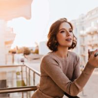 female model holding cup of coffee