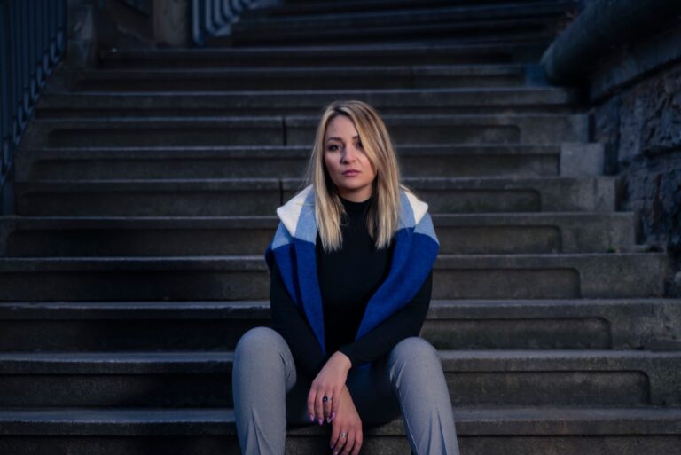 a sad blonde sits on the stairs
