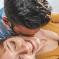 man kissing woman in the neck