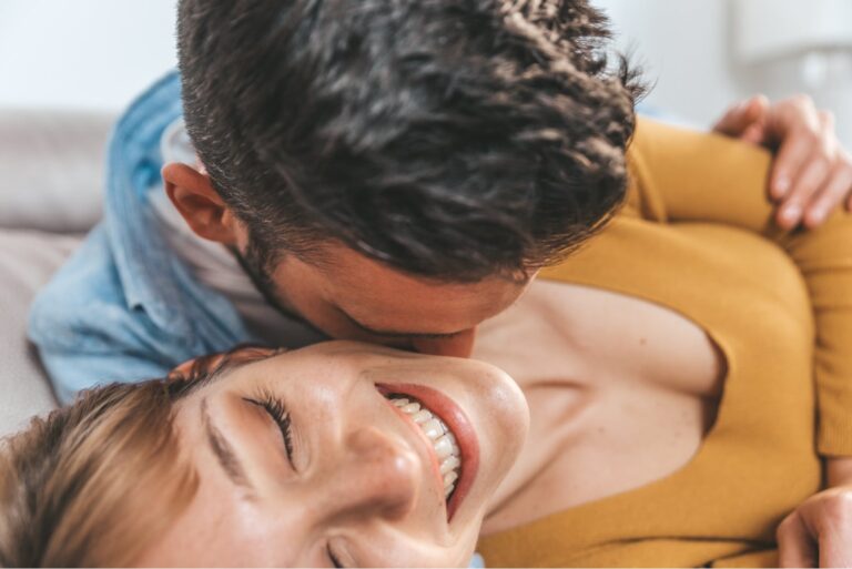 man kissing woman in the neck