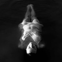 lonely woman laying on water