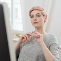 jovem mulher pensativa sentada à mesa