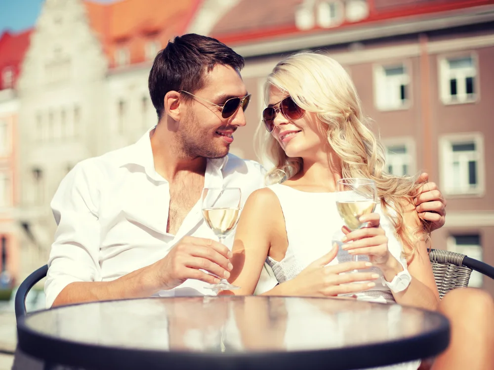 a man and a woman sit drinking wine