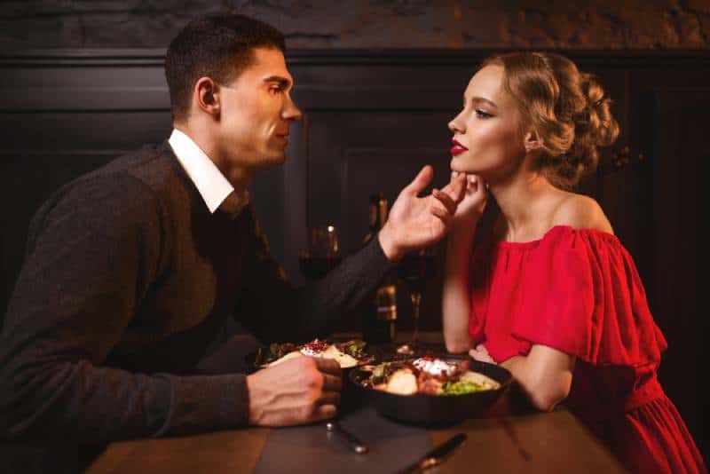 attractive couple looking each other at restaurant