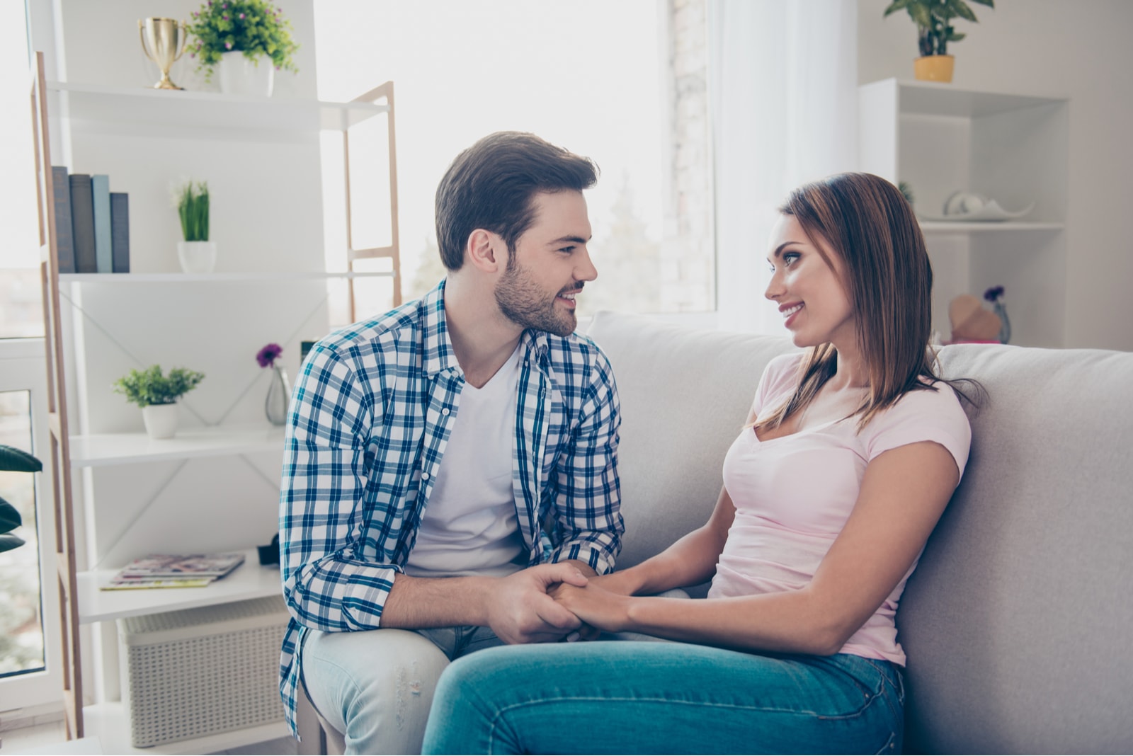 casal apaixonado de mãos dadas no sofá