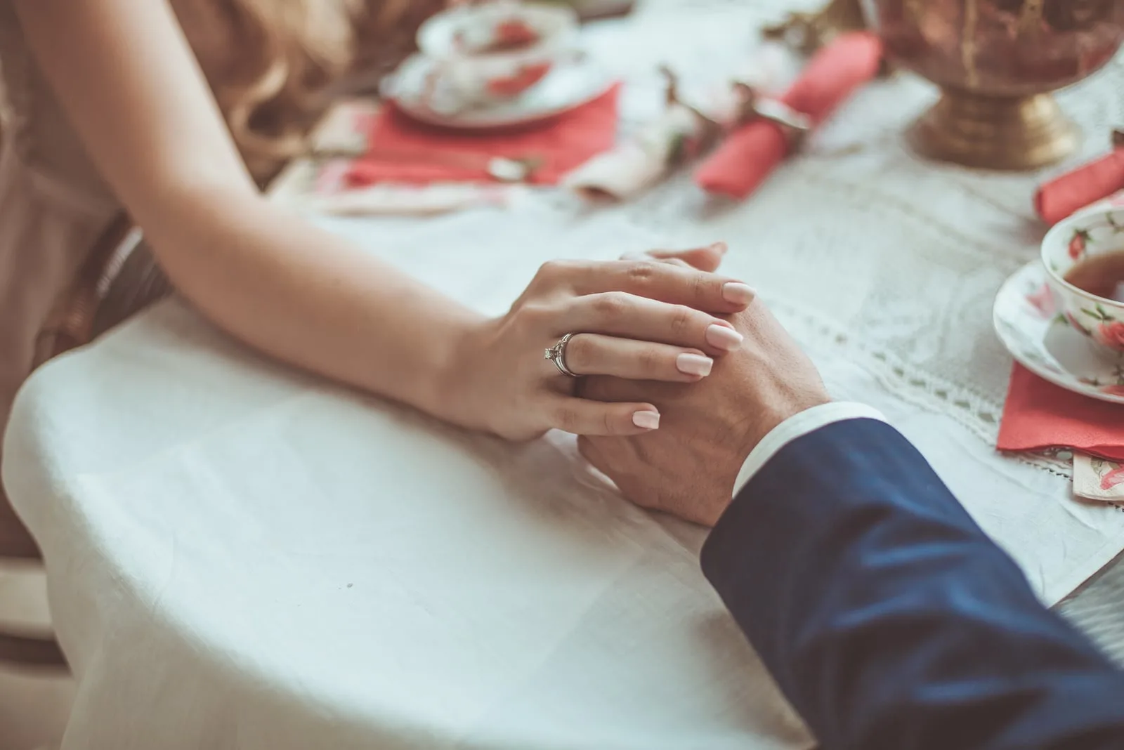 couple holding hands while sitting at the table 