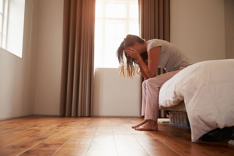 crying woman sitting on bed