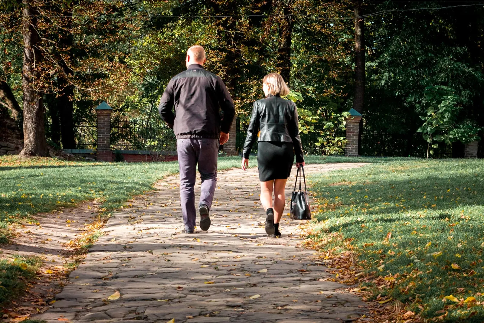 in autumn a man and a woman walk in the park