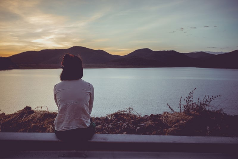 mujer solitaria mirando al lago