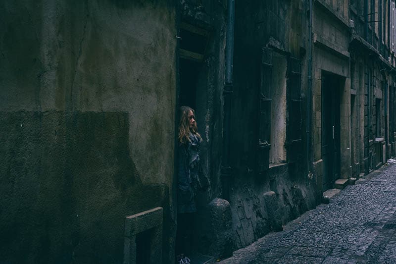 Chica de pie en la puerta de una ruina