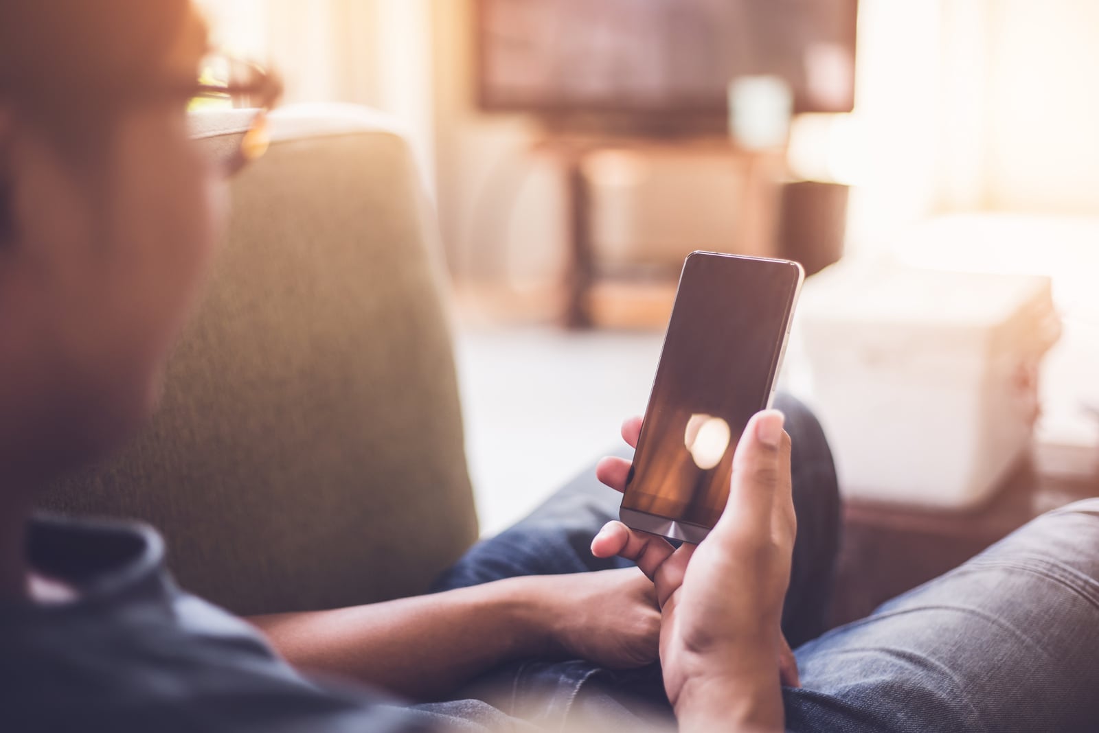 hombre sosteniendo y usando un telefono