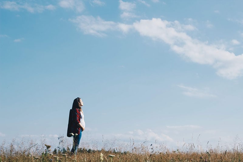 donna incinta in piedi nel campo