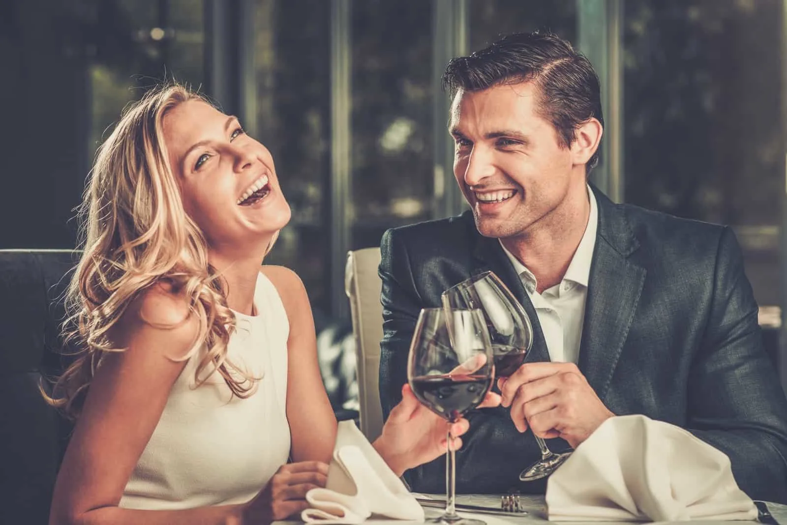 the man and woman at dinner laugh