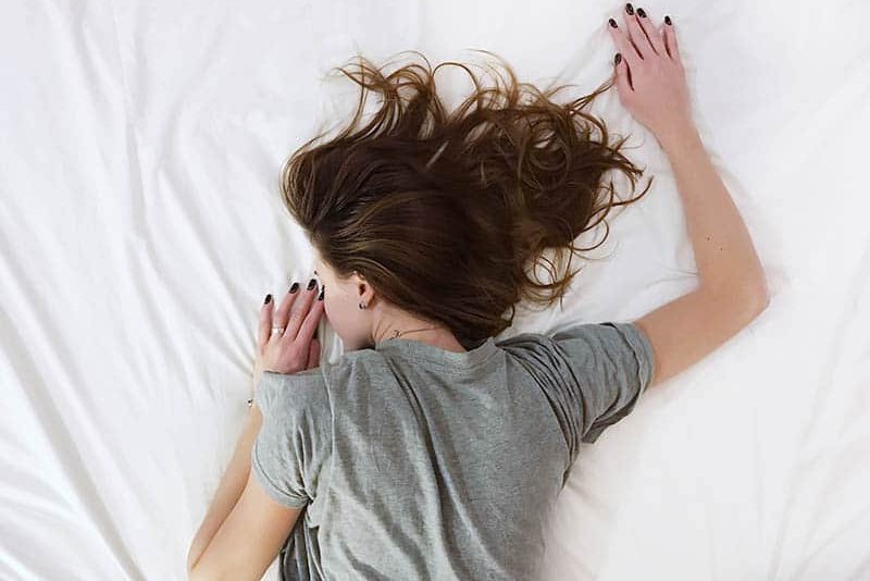 la donna è sdraiata a letto