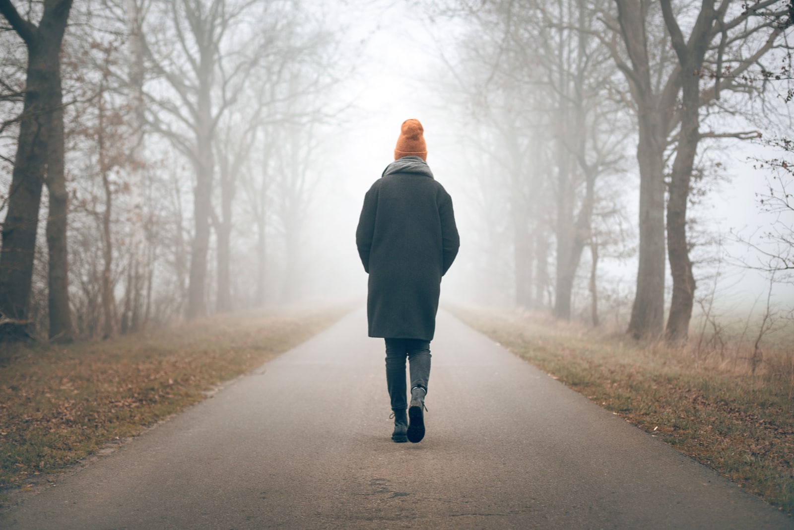woman walking into the distance on a foggy road