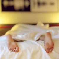 person's feet on bed