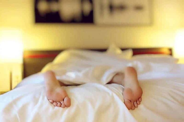 person's feet on bed