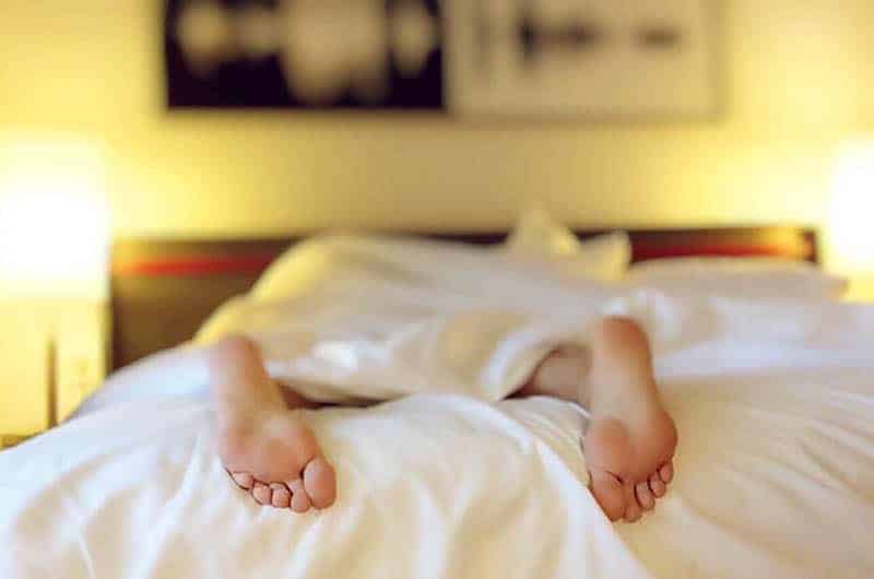 person's feet on bed