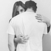 black and white photo of woman hugging man