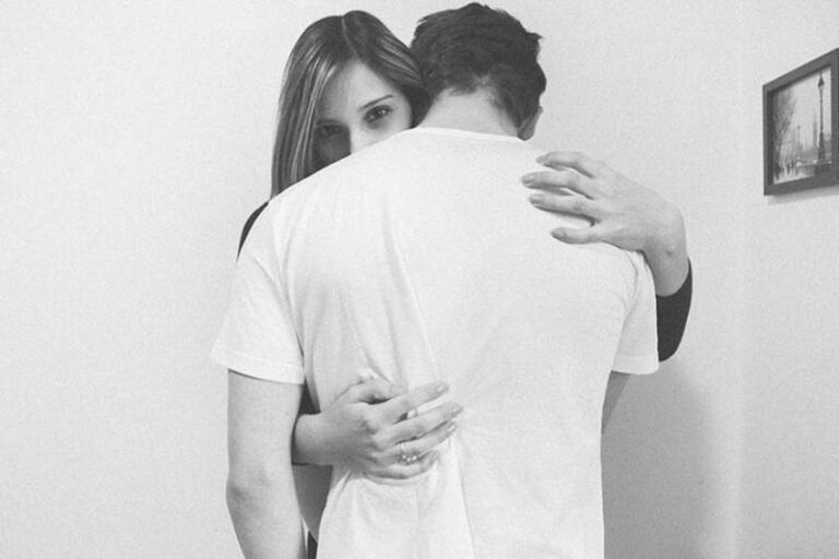 black and white photo of woman hugging man