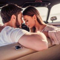 man and woman sitting in the car cuddling
