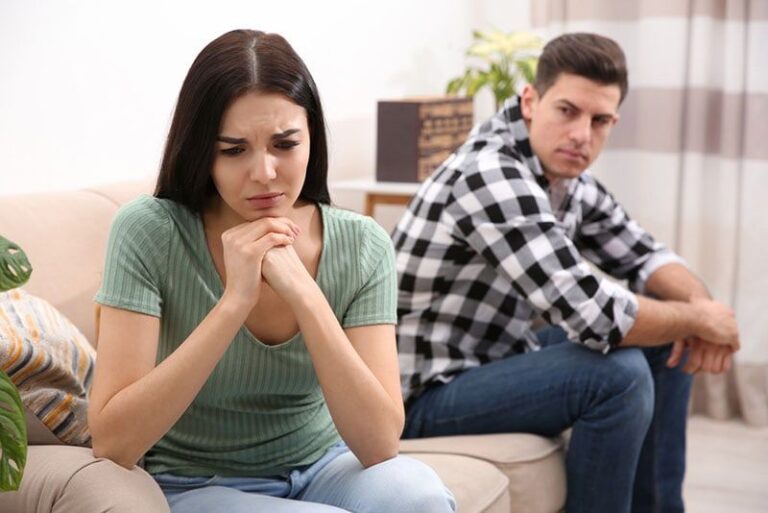 mulher triste sentada no sofá com um homem