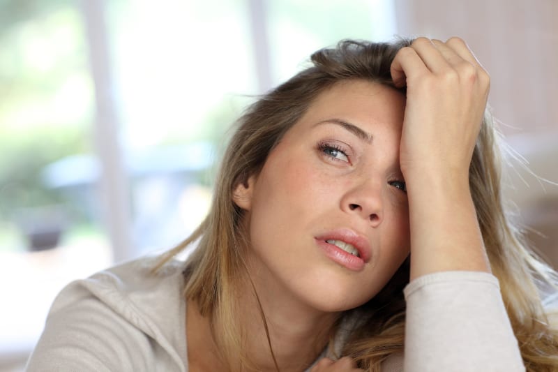 close up photo of blonde worried woman at home