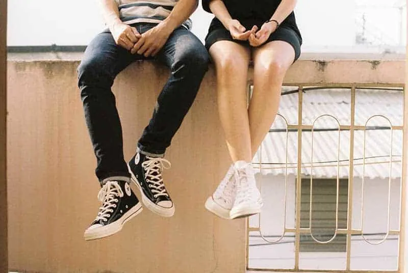 man and woman wearing converse all star sitting beside each other
