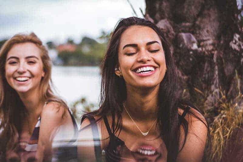 two female friends smiling outside