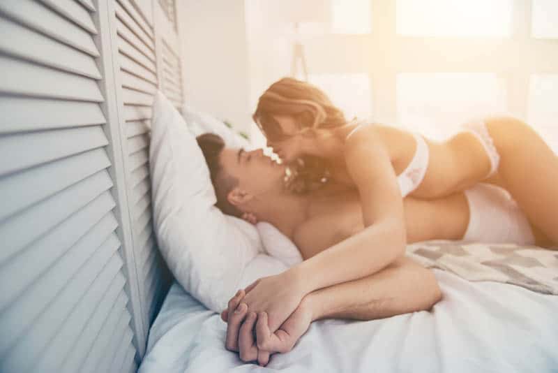 woman on top of man on bed