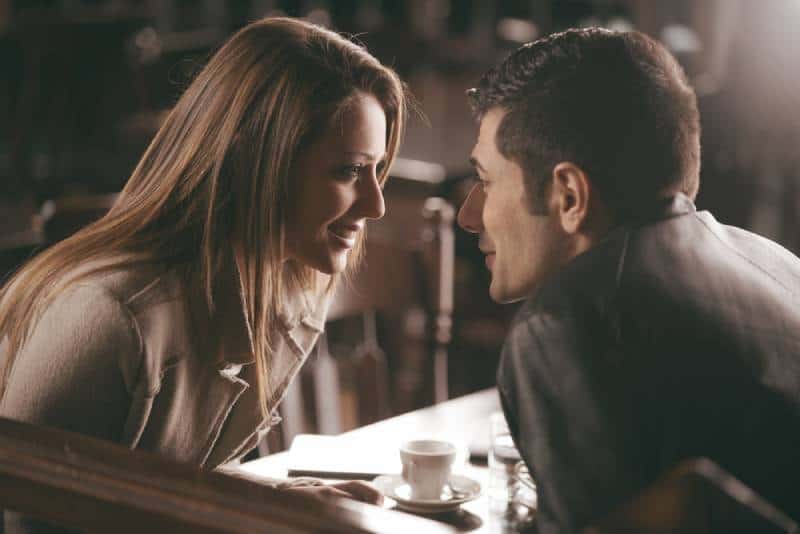closeup of man and woman looking each other at cafe