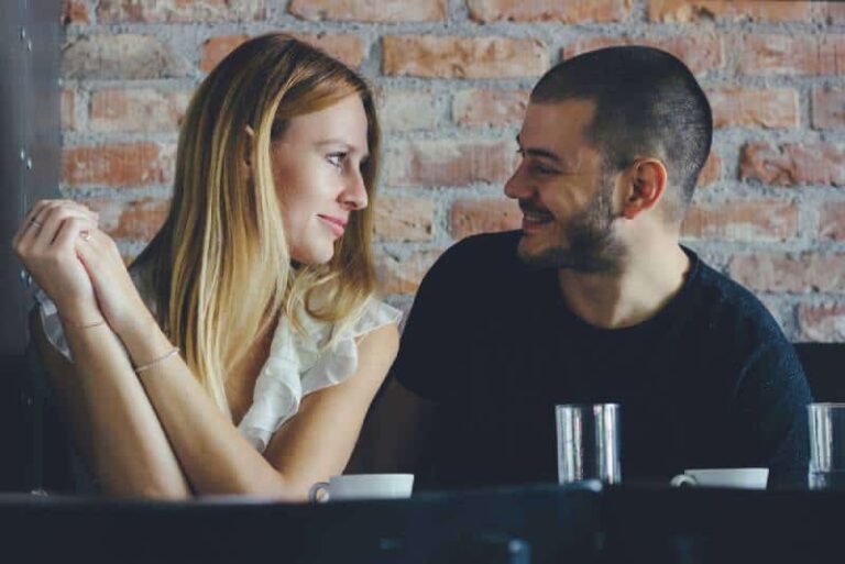 A young man and woman flirting during a date. Couple sitting in cafe