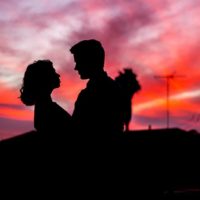 silhouette of man and woman looking each other outside