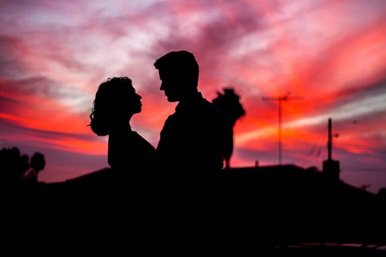 silhouette of man and woman looking each other outside