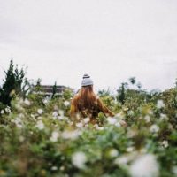 back view of woman standing in green field