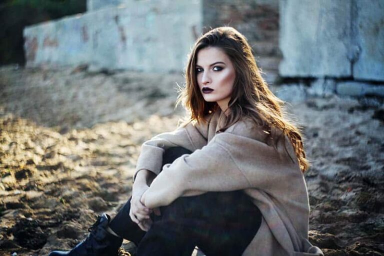 serious brunette wearing sweatshirt and sitting outside