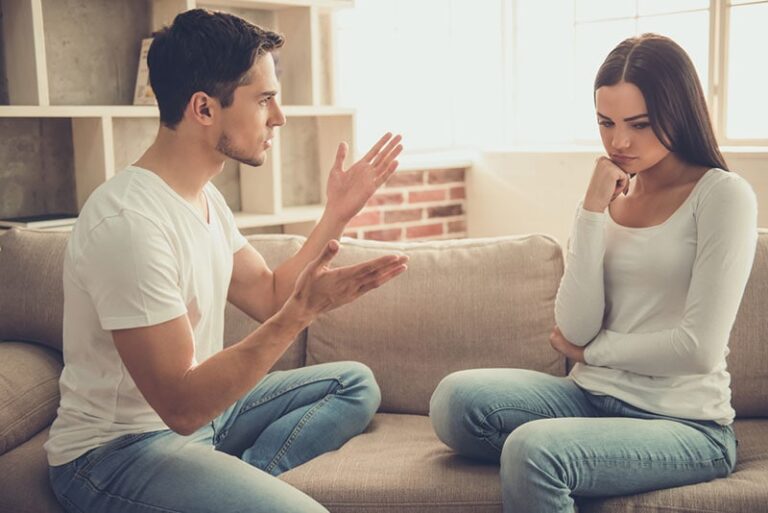 man discussing with woman on the couch