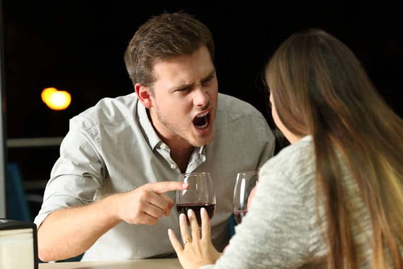 Angry couple arguing furiously in a bar