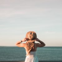 Woman standing alone watching ocean