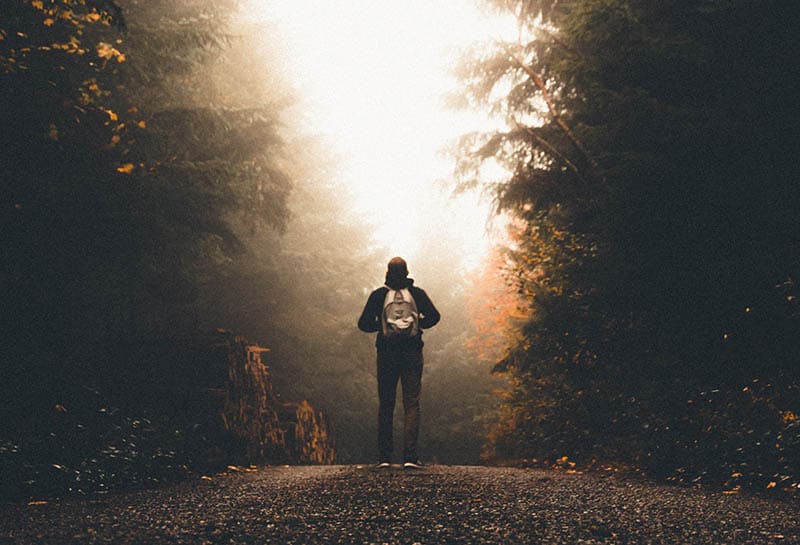 man with backpack in the woods