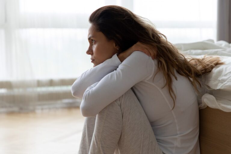 sad woman sitting on the floor in bedroom