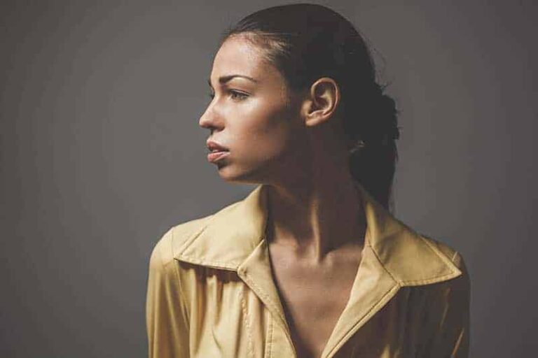serious woman wearing yellow jacket and looking aside