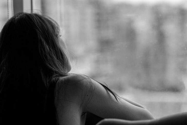 sad woman looking through the window