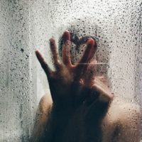 foto ravvicinata di mano di donna su vetro bagnato