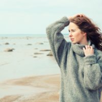 woman wearing a warm cardigan at the cold beach