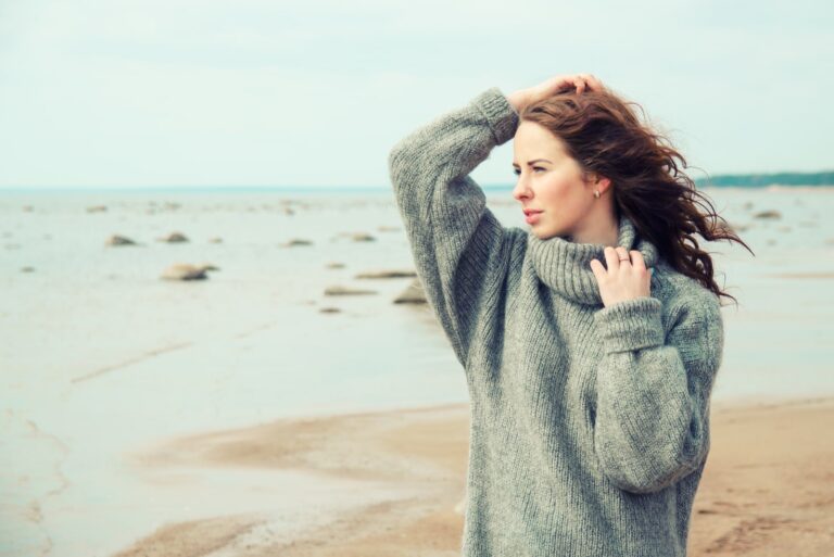 woman wearing a warm cardigan at the cold beach