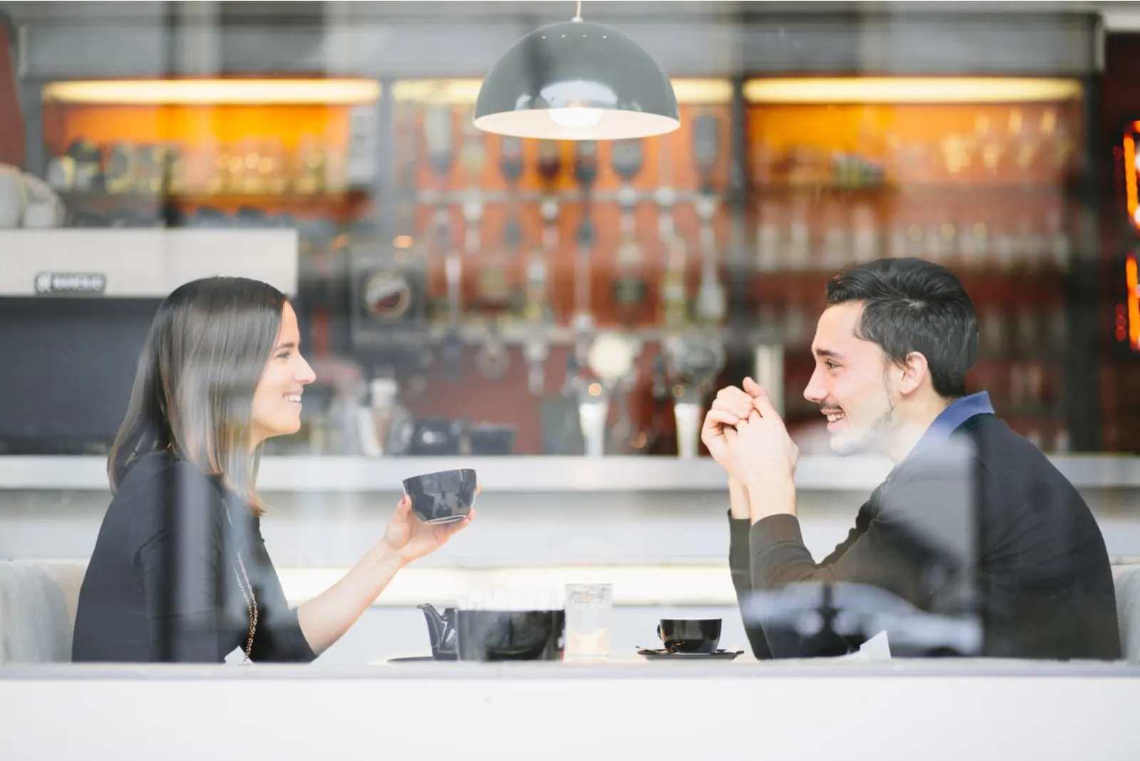 a man and a woman sit and drink coffee