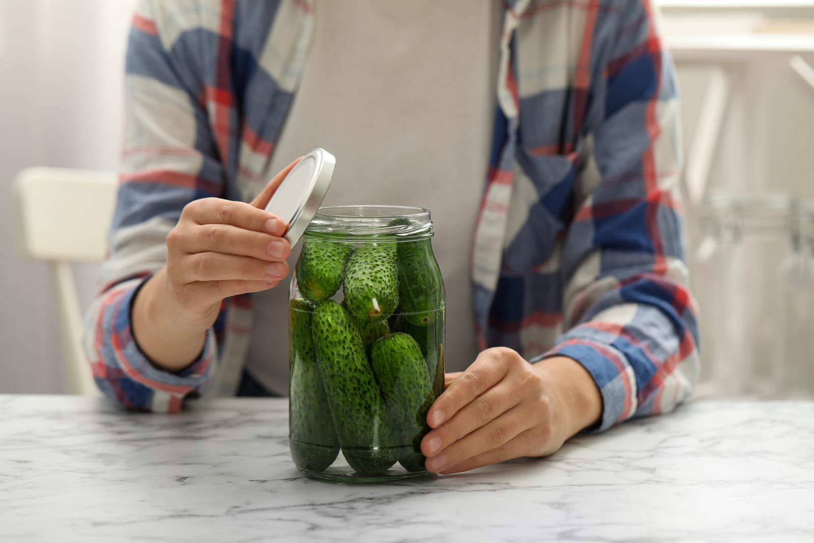 a woman opens a gallon of pickles