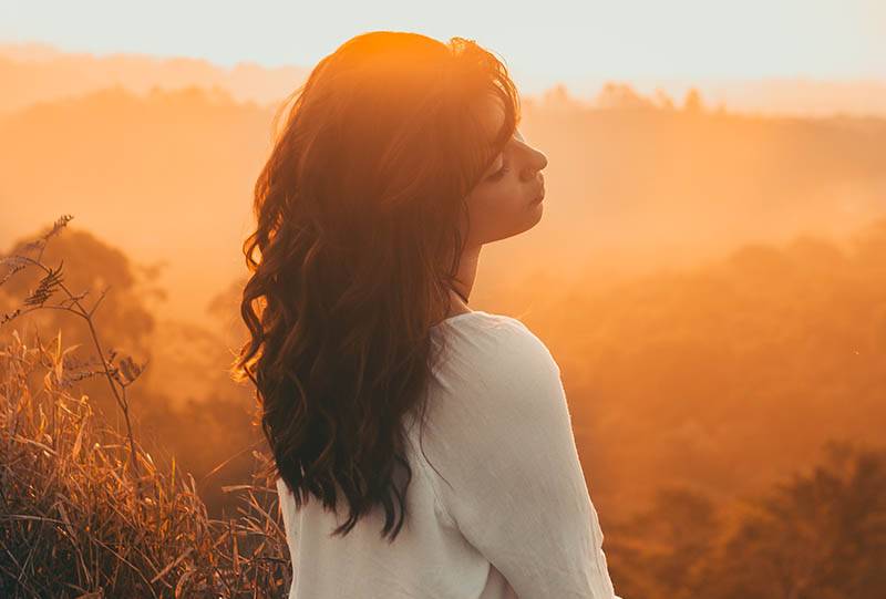 beautiful young woman wearing white shirt outside during golden hour
