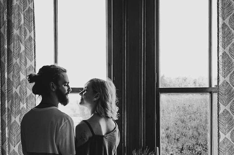 black and white photo of couple looking each other at home
